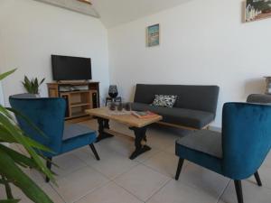 a living room with a couch and a table and chairs at Maison rénovée, 8 pers, animaux admis, jardin - FR-1-540-188 in Notre-Dame-de-Monts
