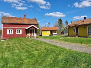 une maison rouge et une maison jaune avec une cour dans l'établissement Holiday home LJUSDAL IV, à Ljusdal
