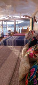 two beds in a room with a view of the ocean at Uros TITIKAKA the Best lodge in Puno