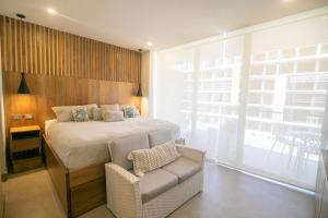 a bedroom with a bed and a chair and a window at Apartamento en Condominio con acceso directo al mar en Cartagena in Cartagena de Indias