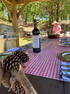 a bottle of wine on a picnic table with a pine cone at Cabañas Chalets Piedra Alta Zacatlan in Camotepec