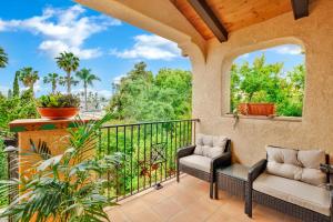 a porch with two chairs and a balcony with trees at Spanish Style Cozy Studio in San Diego