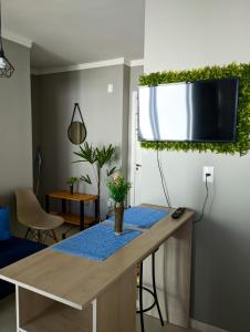 ein Wohnzimmer mit einem Tisch mit einer Pflanze an der Wand in der Unterkunft Cantinho Verde in Santa Maria