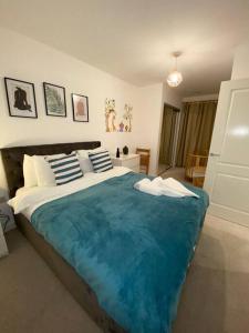 1 dormitorio con 1 cama grande con manta azul en Cozzy apartment in Camberwell en Londres
