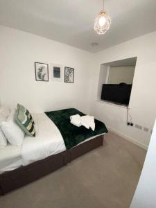 a bedroom with a bed and a flat screen tv at Cozzy apartment in Camberwell in London