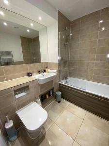 La salle de bains est pourvue de toilettes, d'un lavabo et d'une baignoire. dans l'établissement Cozzy apartment in Camberwell, à Londres