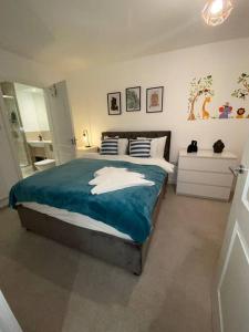 - une chambre avec un grand lit et une couverture bleue dans l'établissement Cozzy apartment in Camberwell, à Londres