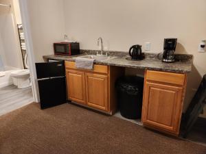 a kitchen with a sink and a microwave at Stay Inn Niagara Falls Vacation Studios in Niagara Falls