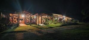 une maison éclairée la nuit dans l'établissement Oski Lodge, Rain Forest Rincón de la Vieja, à Upala
