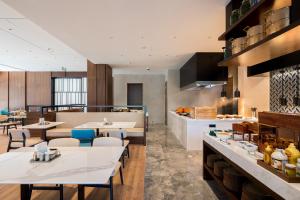 um restaurante com mesas e cadeiras e uma cozinha em Fairfield by Marriott Shanghai Hongqiao NECC em Xangai