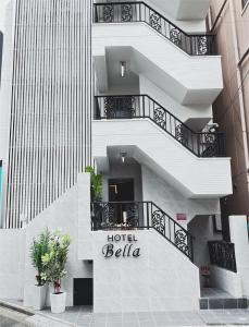 a white hotel bellula building with stairs and plants at Sakura Bella Ikebukuro in Tokyo
