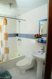 a white bathroom with a toilet and a sink at Apto CALETA BEACH 3HAB in La Romana