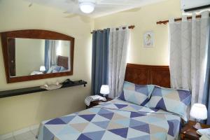 sypialnia z łóżkiem i dużym lustrem w obiekcie Apto CALETA BEACH 3HAB w mieście La Romana