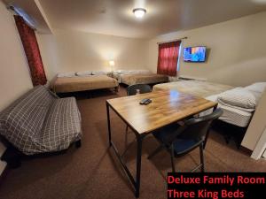 a hotel room with three king beds and a table at Stay Inn Niagara Falls Vacation Studios in Niagara Falls