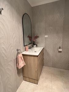 een badkamer met een wastafel en een spiegel bij Cosy Eildon Getaway in Eildon