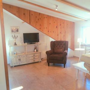 a living room with a chair and a television at Luxury Mansarda Duplex - CITY CENTRE - Stone House in Split