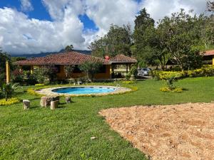 a yard with a swimming pool in front of a house at Casa Campestre Sueño Verde in Garagoa