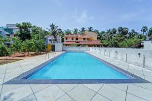 a swimming pool in front of a house at OYO Flagship Le Gith De Charme with swiming pool in Kottakupam