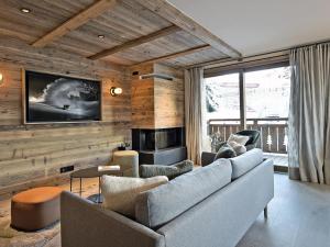 un soggiorno con divano e camino di Appartement neuf avec terrasse, SPA, 3 chambres et services hôteliers - Méribel Les Allues - FR-1-613-22 a Méribel