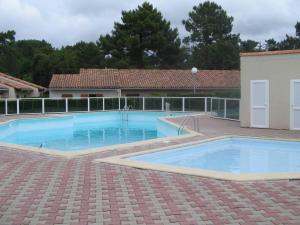 een groot blauw zwembad in een tuin bij Maison Les Mathes, 1 pièce, 4 personnes - FR-1-738-7 in Les Mathes