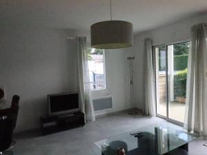 ein Wohnzimmer mit einem Glastisch und einem TV in der Unterkunft Appartement Meschers-sur-Gironde, 3 pièces, 4 personnes - FR-1-738-1 in Meschers-sur-Gironde