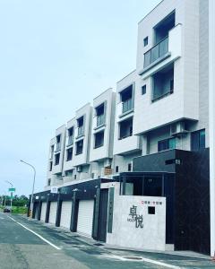 un edificio blanco alto al lado de una calle en 安平包棟民宿 - 尋雨 - 台南民宿Ktv影音室限包棟使用 en Tainan