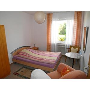 a living room with a bed and a window at Haus am See in Horn-Bad Meinberg