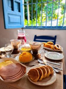 uma mesa com pratos de comida e pão em Casa Igarassu em Igarassu