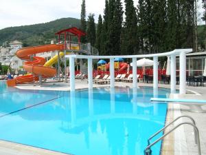 een groot zwembad met een glijbaan bij Kamares Apartments ΕΕ in Poros