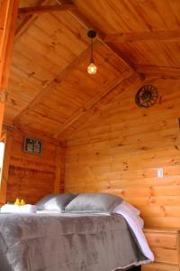 a bedroom in a log cabin with a clock on the ceiling at Camping & Cabaña San Francisco - Guatavita in Guatavita