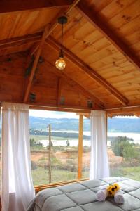 a bedroom with a bed and a large window at Camping & Cabaña San Francisco - Guatavita in Guatavita
