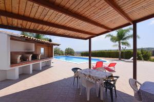 a patio with a table and chairs and a swimming pool at Holiday Home Floridia - ISI02274-F in Floridia