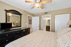 1 dormitorio con 1 cama con ventilador de techo y TV en Pelican Beach 0908 by Pelican Beach Management, en Destin