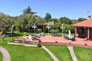 un jardín con patio y un pabellón con sillas y mesas en Holiday Home Solarino - ISI02255-F, en Solarino
