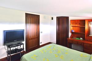 1 dormitorio con 1 cama y TV en Holiday Home Solarino - ISI02255-F, en Solarino