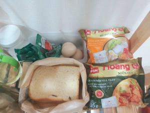 un cestino per il pranzo con un panino e uova e patatine di The mini apartment includes breakfast a Hanoi