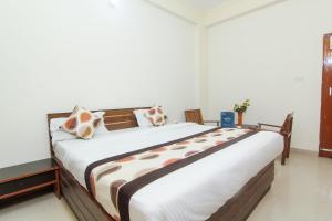 um quarto com uma cama grande com almofadas em OYO Hotel Indiana Near Gomti Riverfront Park em Vibhuti Khand