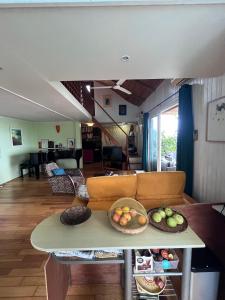 een woonkamer met een bank en een tafel met fruit erop bij La maison des artistes in Saint-Leu