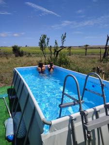 twee mensen in een zwembad in een veld bij Tranquilo Glamping in Hozanejos