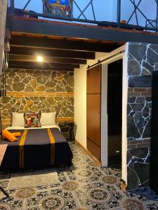 ein Schlafzimmer mit einem Bett und einer Steinmauer in der Unterkunft Casa Santiago de los Caballeros in Antigua Guatemala