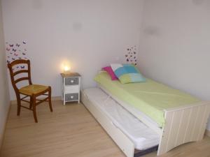 a small bedroom with a bed and a chair at Appartement confortable proche plage avec balcon - Saint-Jean-de-Monts, 2 chambres, parking inclus - FR-1-224C-245 in Saint-Jean-de-Monts