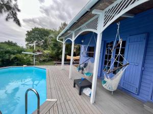 een blauw huis met een zwembad en een veranda bij La maison des artistes in Saint-Leu