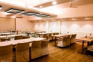 una sala de conferencias con mesas, sillas y una pizarra en The Legend Inn Delhi, en Nueva Delhi