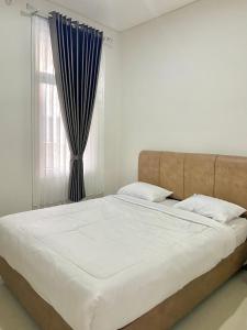 um quarto com uma cama grande e uma janela em Villa Ku Villa Mu em Semarang