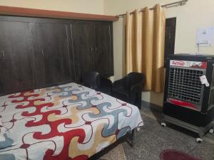 a bedroom with a bed and chairs and a cabinet at Krishna Kunj Homestay Rishikesh in Rishīkesh