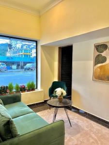 a living room with a couch and a table and a window at Melur Inn in Cameron Highlands