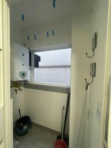 Baño pequeño con ventana con cinta azul en la pared en Cómodo dos ambientes en Buenos Aires