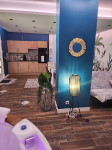 una sala de estar con una pared azul y una lámpara. en La tropicale gite avec Spa 2-4 personnes, 