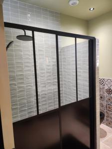 puerta de ducha de cristal con ventana en el baño en La tropicale gite avec Spa 2-4 personnes, 
