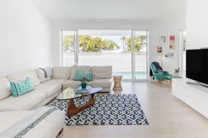 a living room with a white couch and a tv at Poinciana House—Luxury Noosa Retreat close to Beach in Noosa Heads